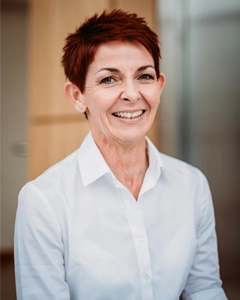 PA to the chief executive in a white shirt, smiling in a modern office