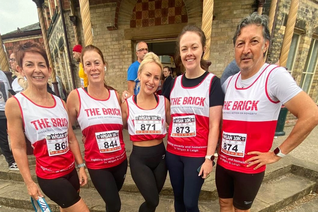 ASL team at the Wigan 10k wearing The Brick charity vests outside the event venue, September 2024.